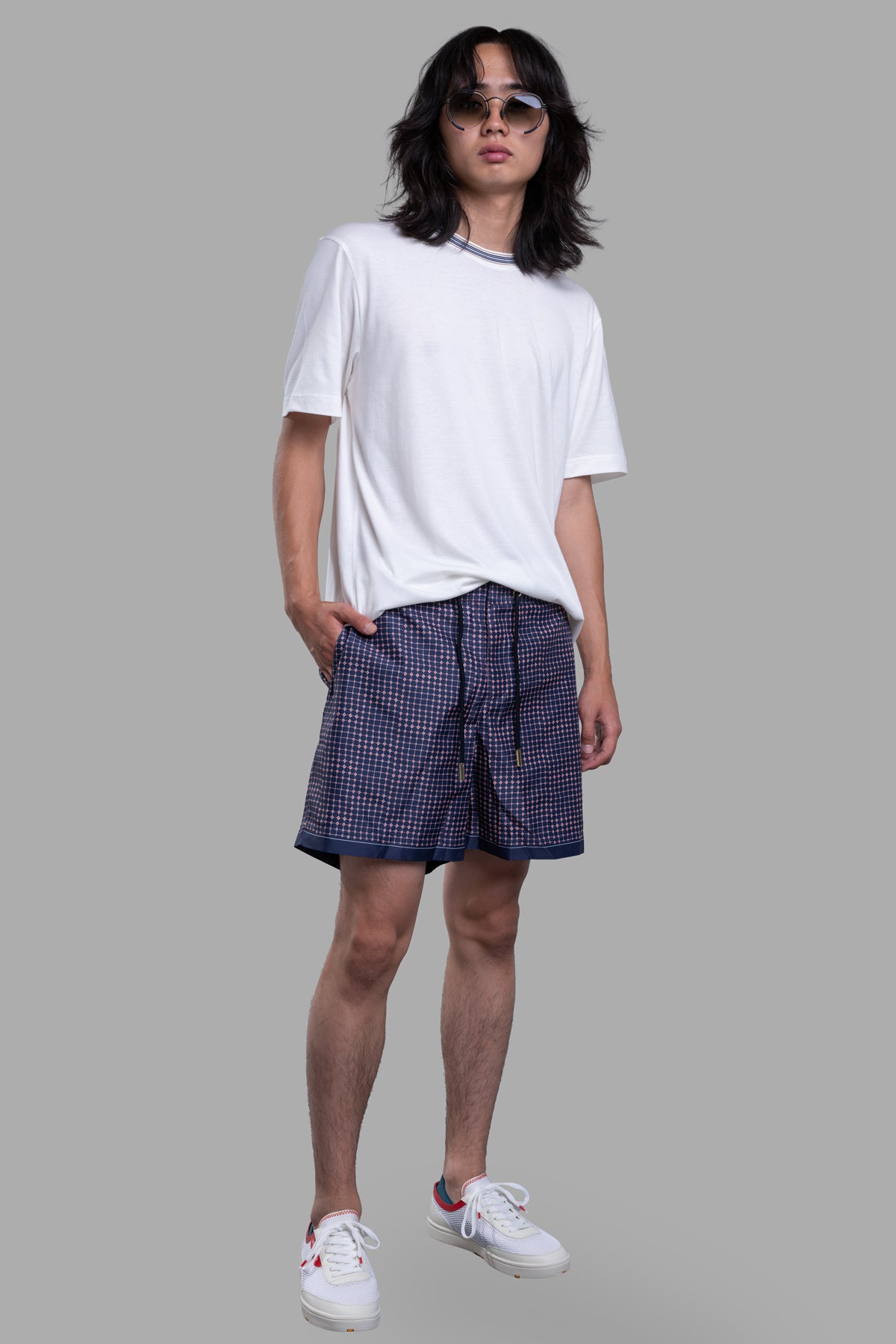 Orlebar Brown Drawcord Swim Shorts featuring blue-red diamond print, modeled with white tee and sneakers, front view.