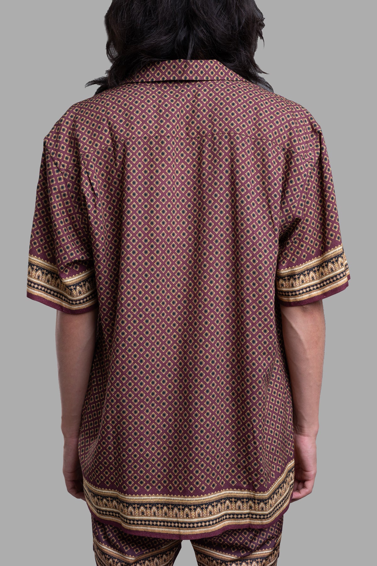 Orlebar Brown Relaxed-Fit Capri Shirt, showcasing the back detail of the deep red floral print and striped paisley hem.