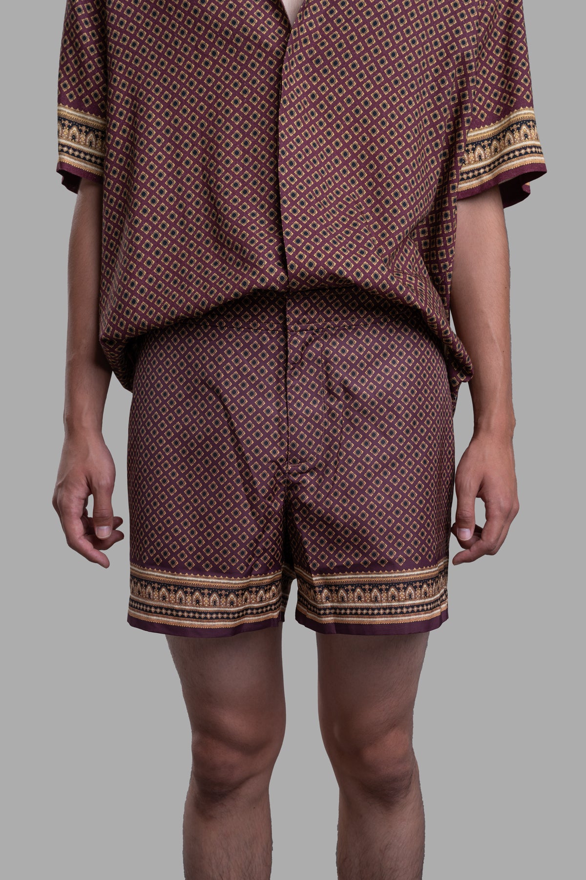 Orlebar Brown Copper Swim Shorts with floral print, gold-effect side, showcasing retro style and comfort by the pool.