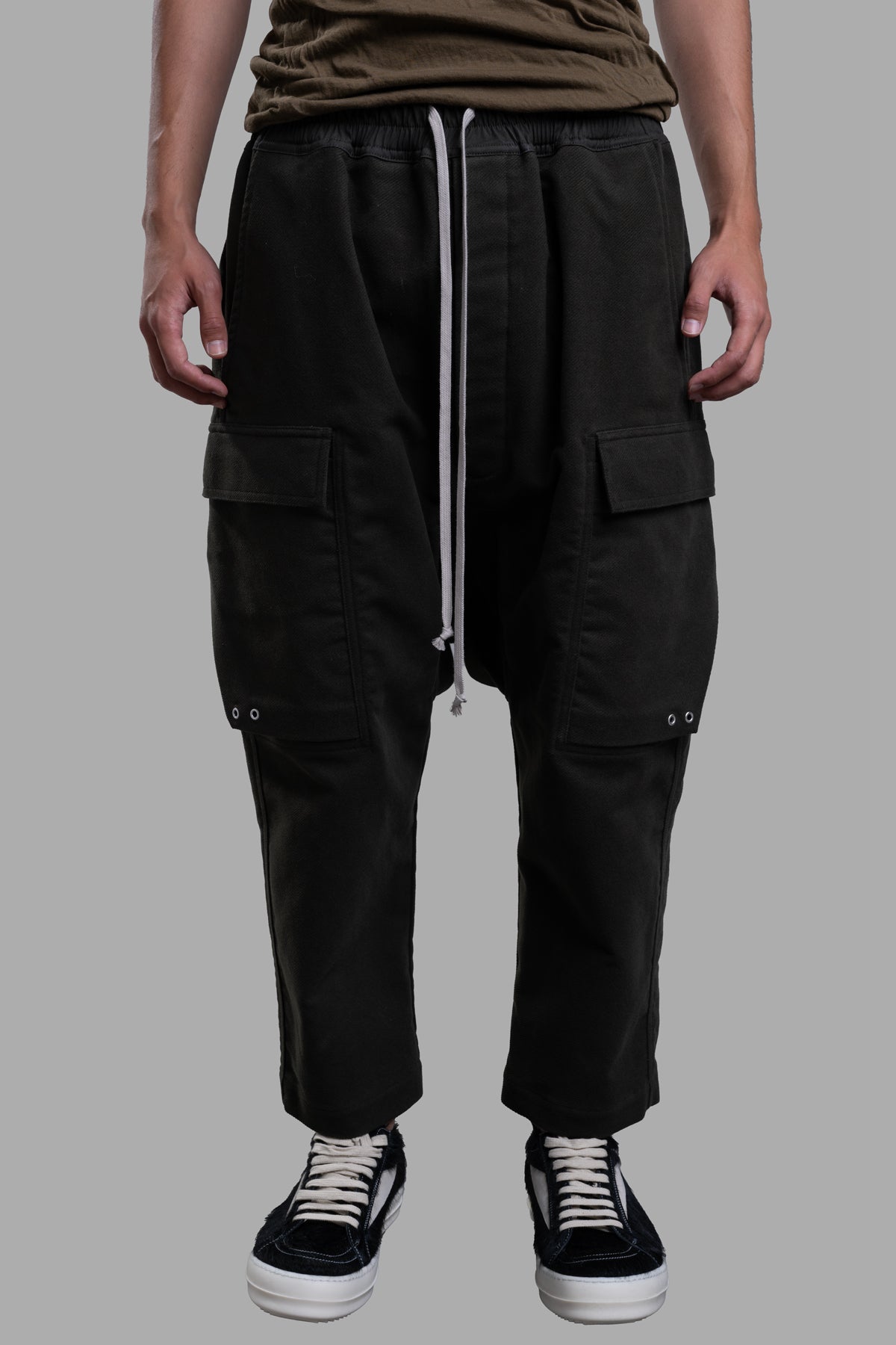 Rick Owens Cropped Drawstring Pants in green, featuring a dropped crotch, elastic waist, and multiple pockets, model shot.