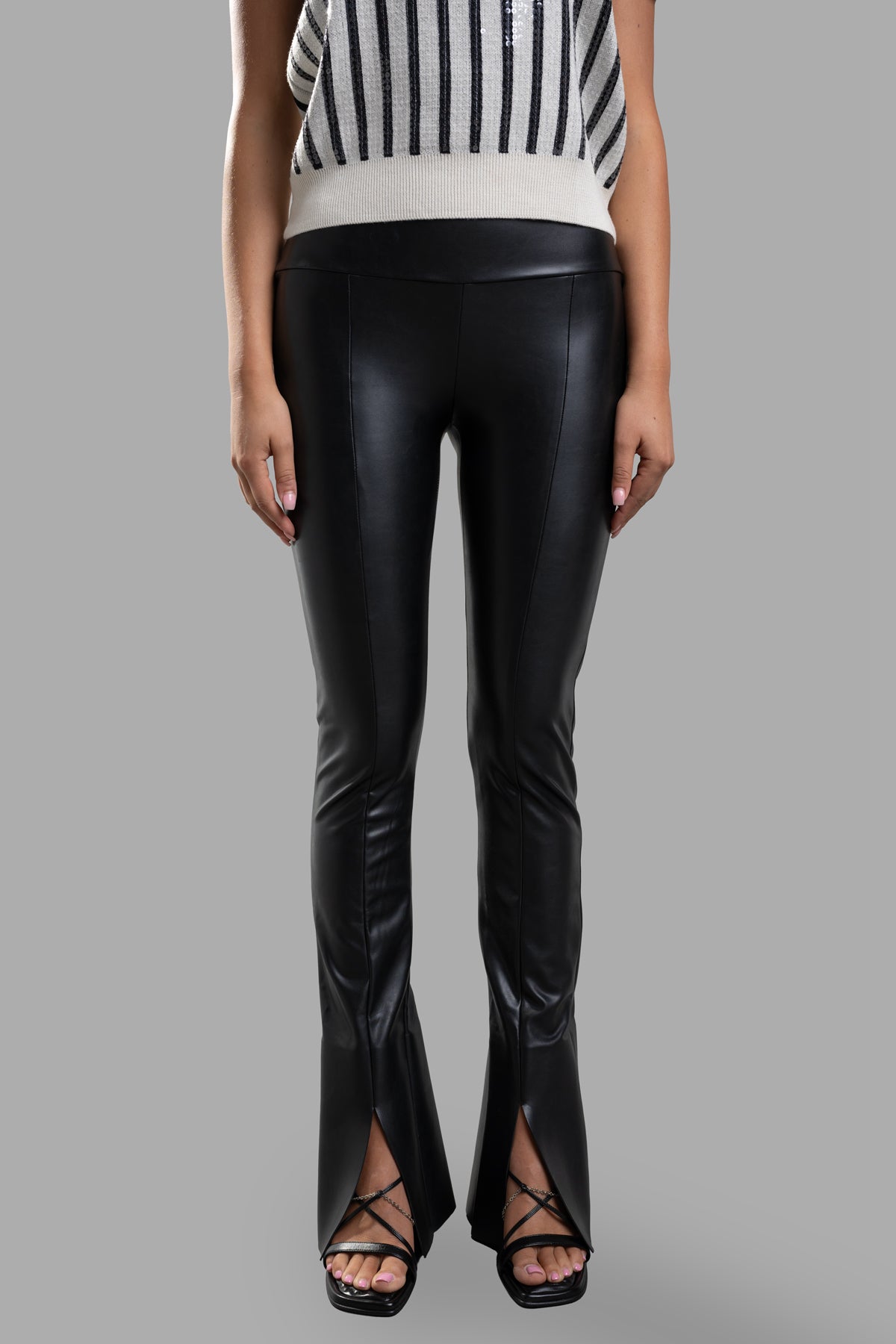 Norma Kamali Spat Leggings in black featuring a slim fit, high waist, and stylish center cut slit, showcased on model.