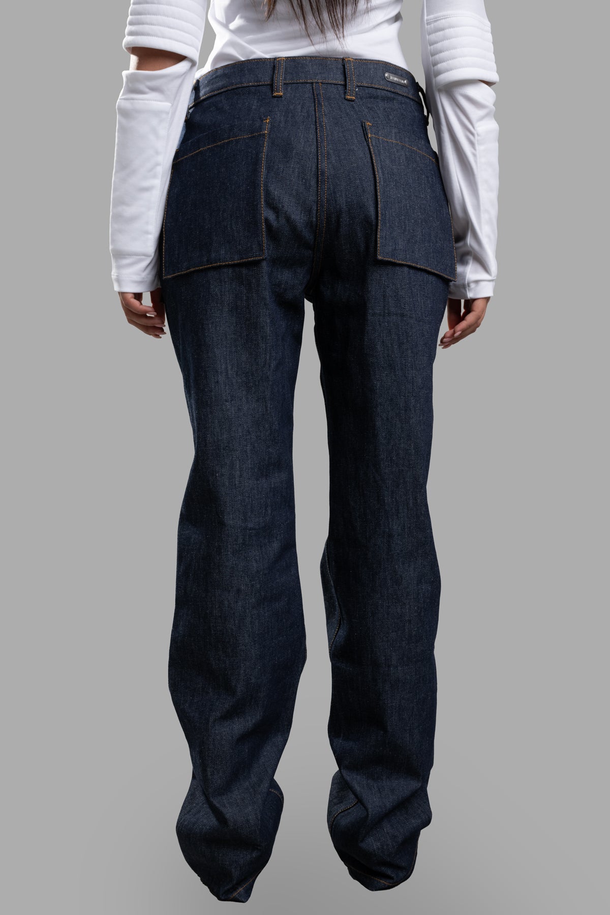 Helmut Lang Utility Jeans showcasing the back view in dark blue raw indigo denim with utility pockets.