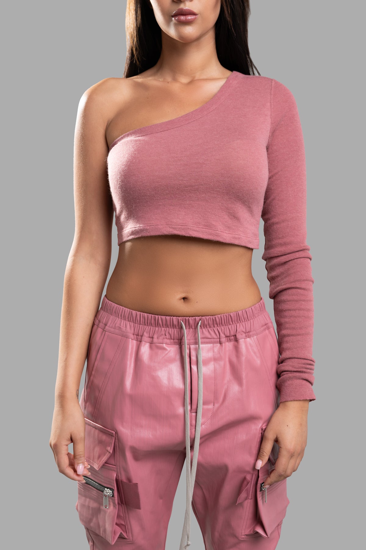 Rick Owens Ziggy Asymmetric Top in pink, featuring an edgy asymmetric design and long sleeve, styled with cargo pants.