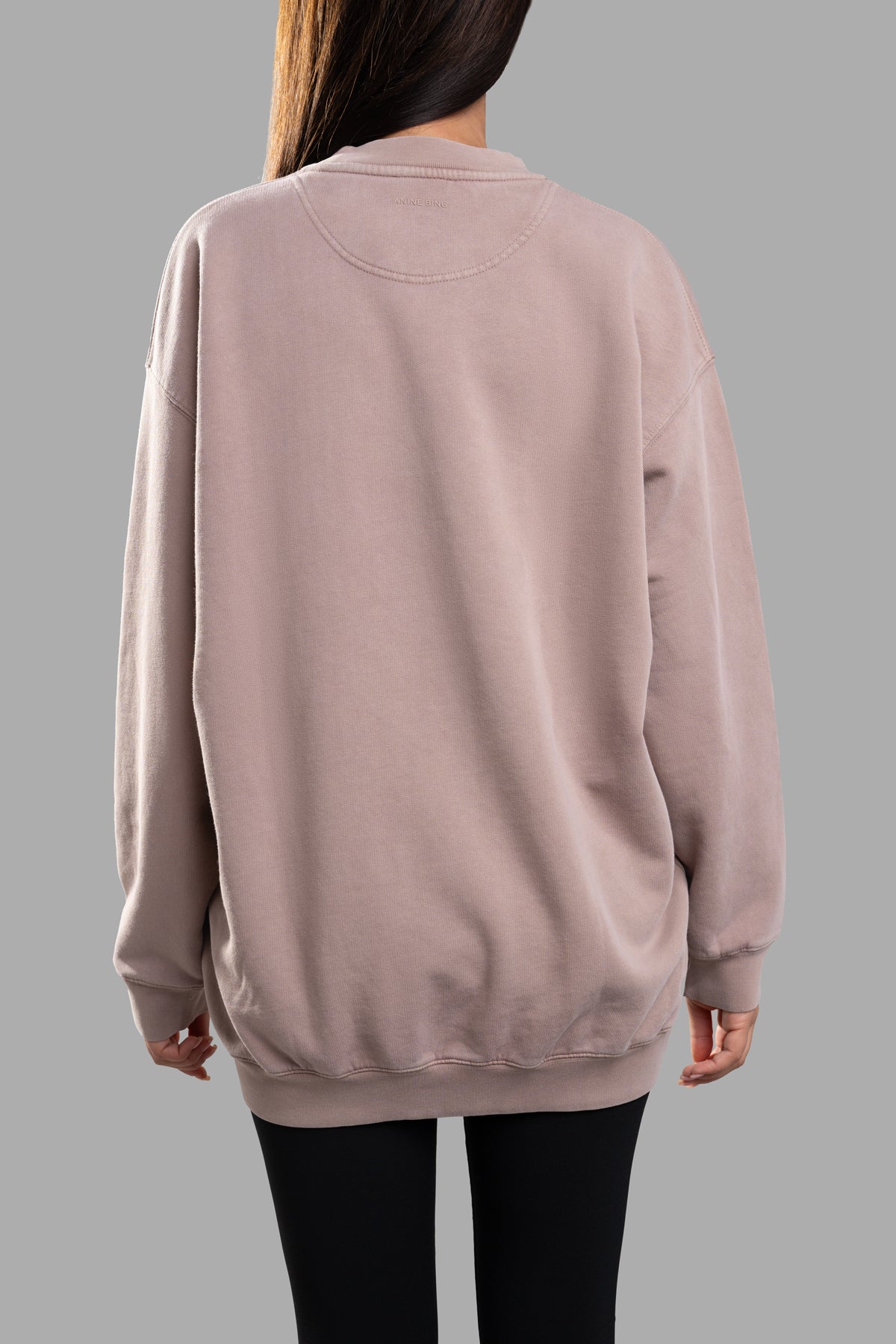 Anine Bing Tyler Logo Sweatshirt in purple, oversized crewneck view from back showcasing ribbed hem and soft cotton fleece.
