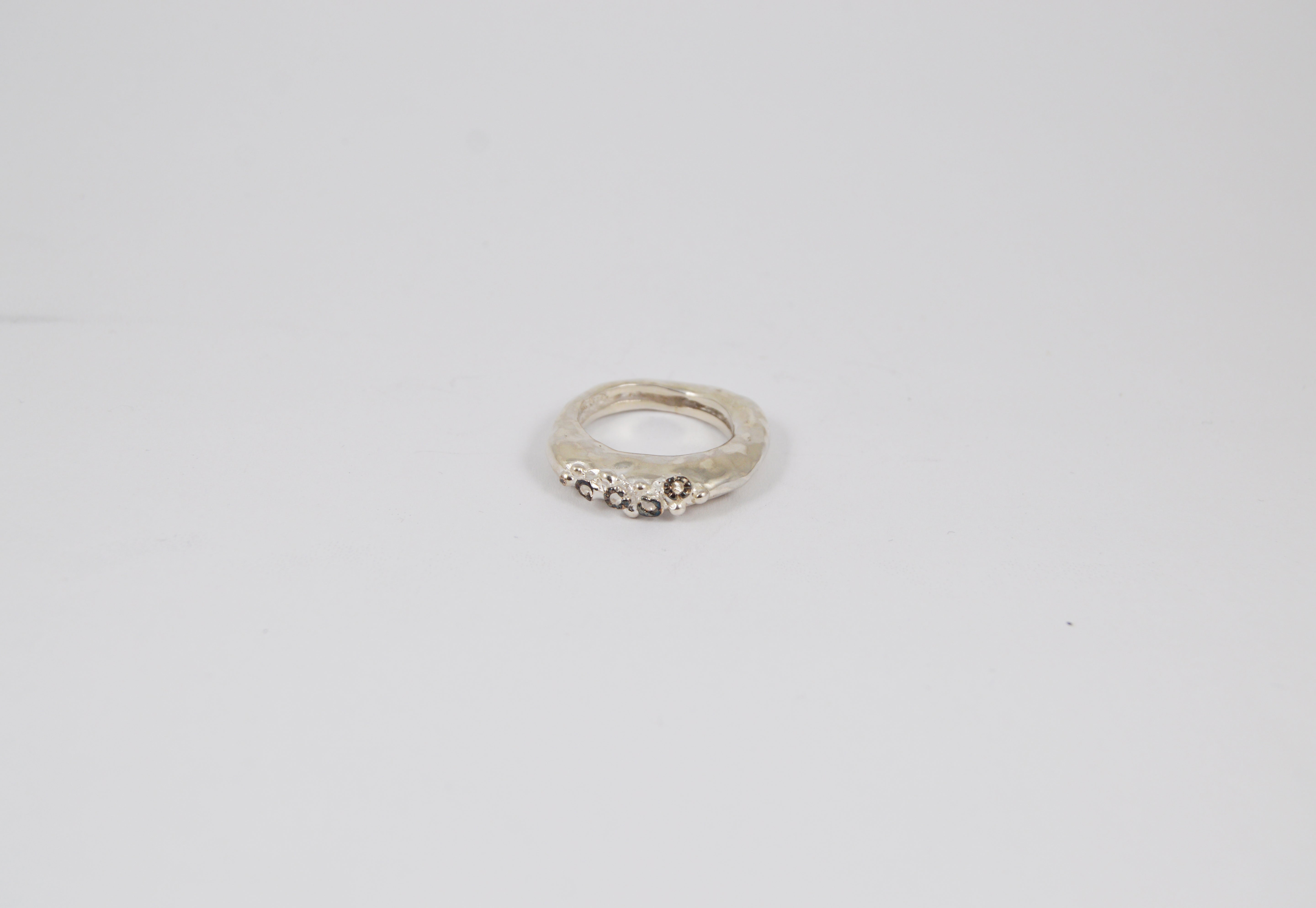 Rosa Maria Razan 3 Ring features raw, organic silver with icy grey diamonds, showcasing a unique handcrafted design.