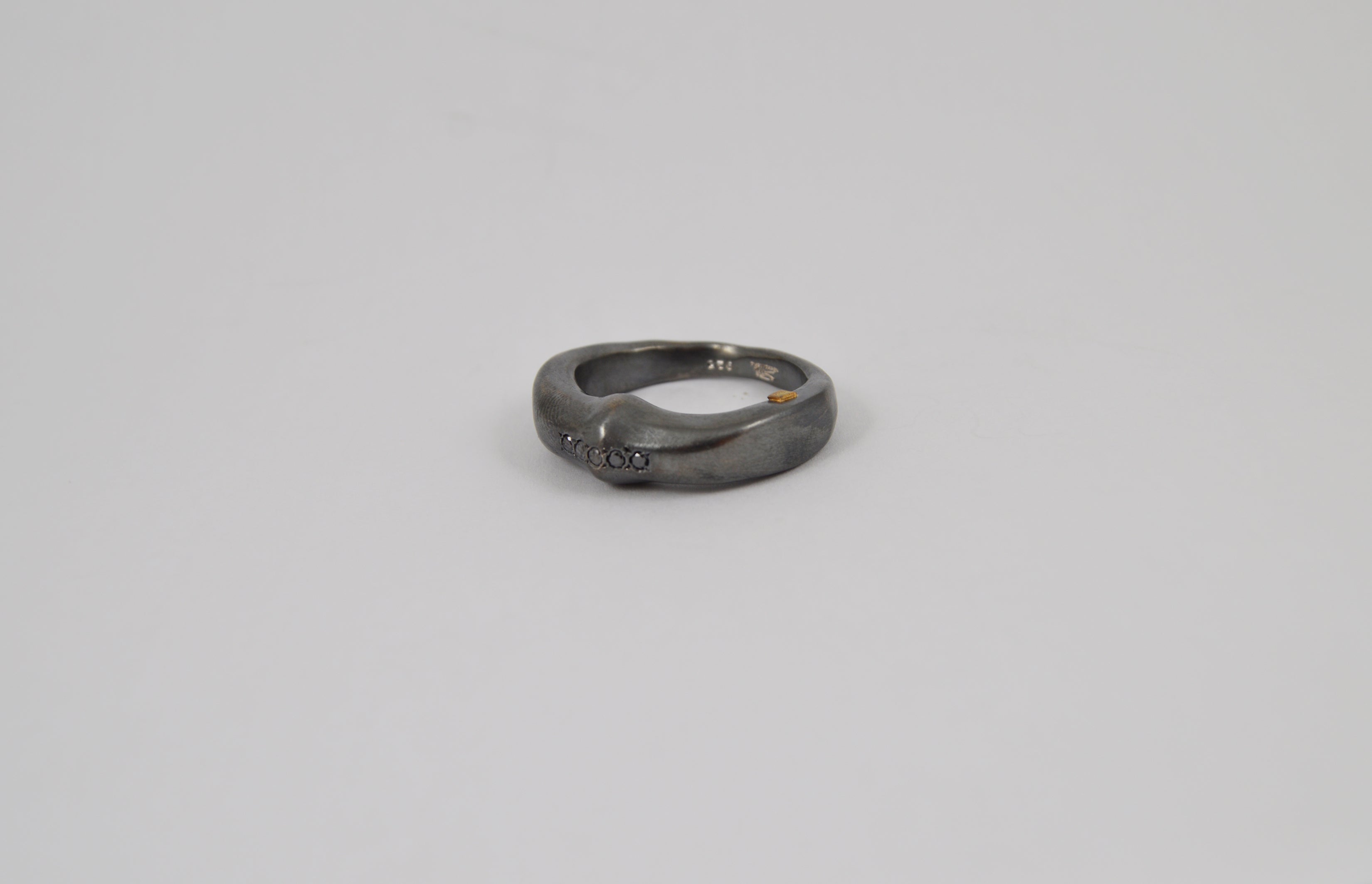 Rosa Maria Siwa Ring, silver with raw organic shape, features black diamonds; close-up of handcrafted imperfections.