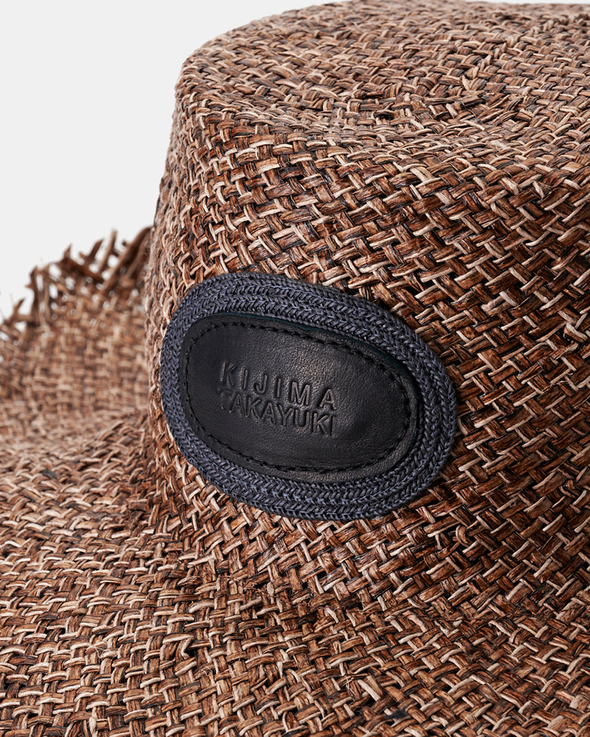 Kijima Takayuki Wide-brim Straw Hat close-up showcasing intricate raffia texture and elegant leather logo detail.