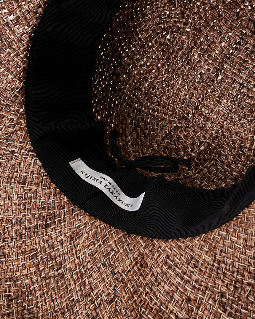 Kijima Takayuki Wide-brim Straw Hat showcasing detailed brown raffia weave with inner black band, highlighting craftsmanship.