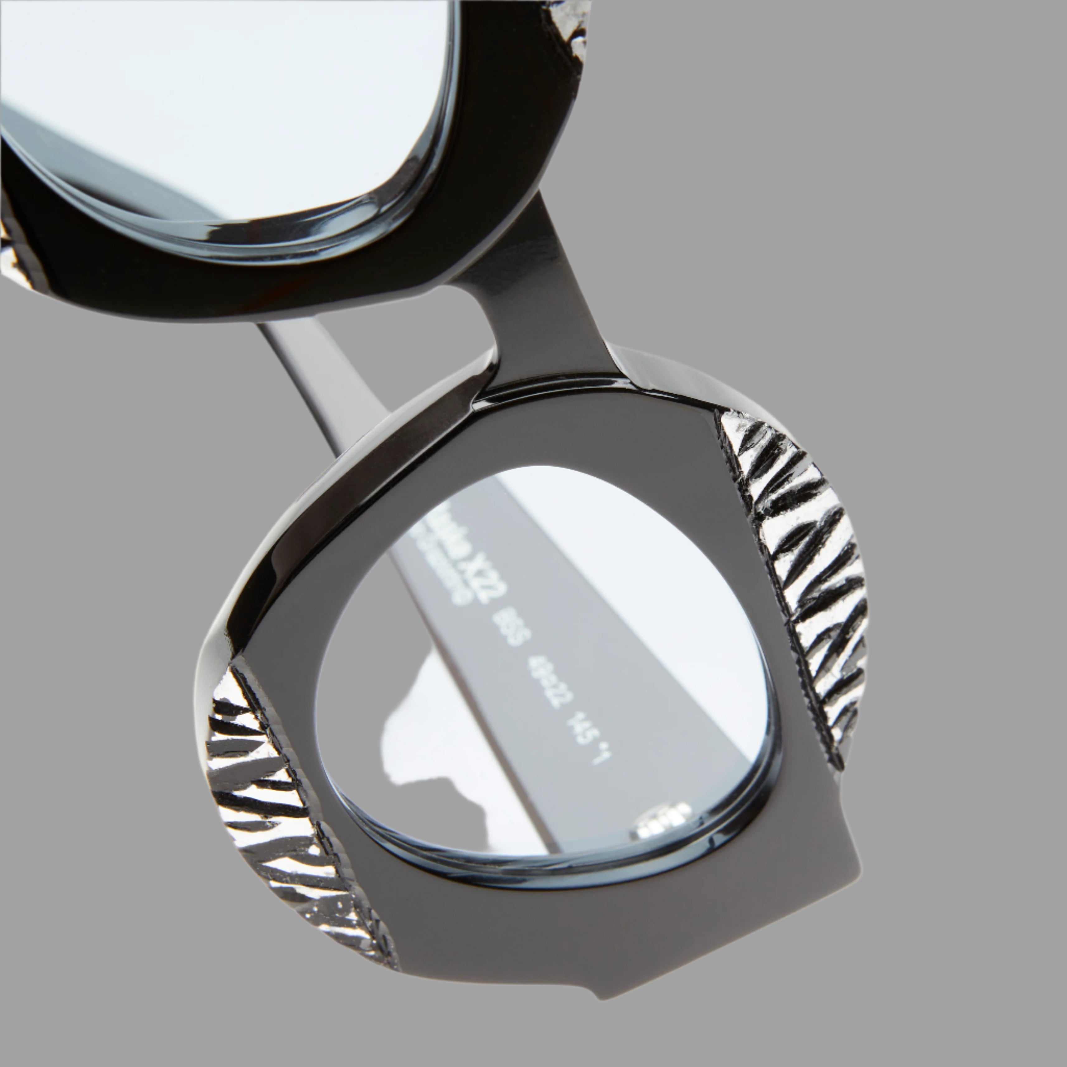 Kuboraum Berlin Mask X22, close-up view of unique black silhouette with textured accents and light blue lenses.