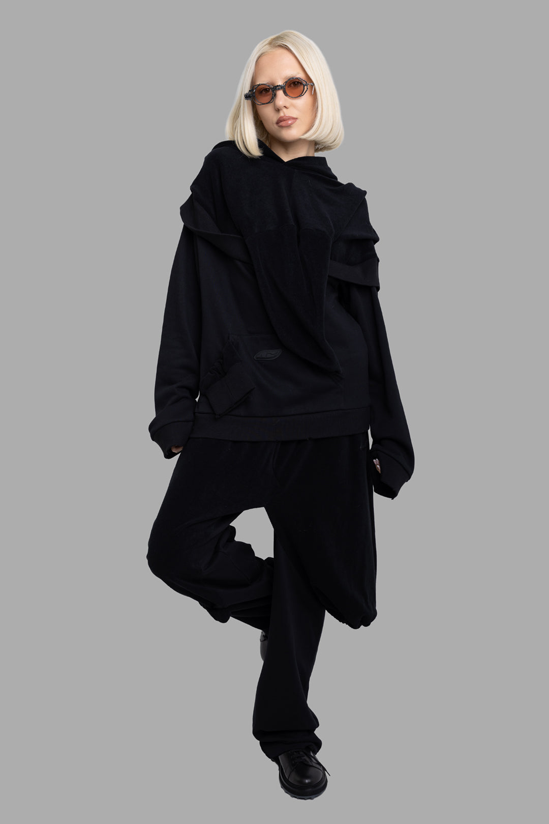 Natasha Zinko unisex Aftercare hoodie in black, full-length front on model with oversized fit and draped layered hood