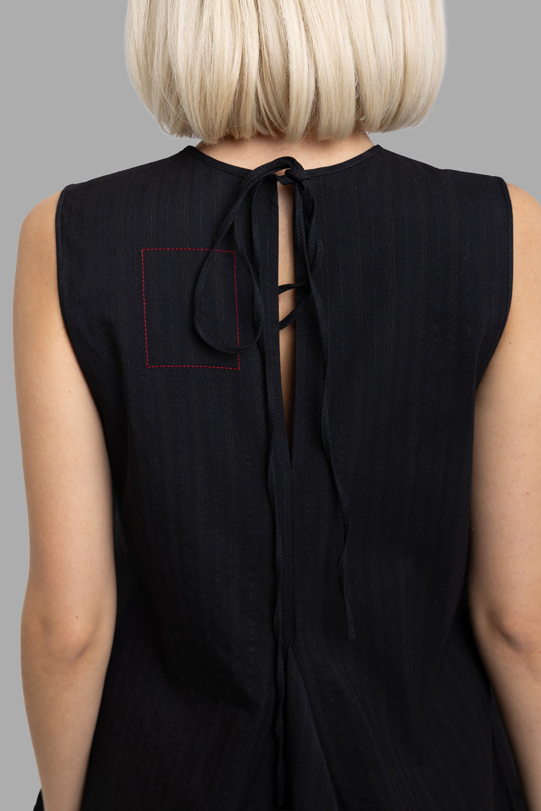 Uma Wang women's black Alani dress, back neck detail showing tie closure and contrast red square stitching
