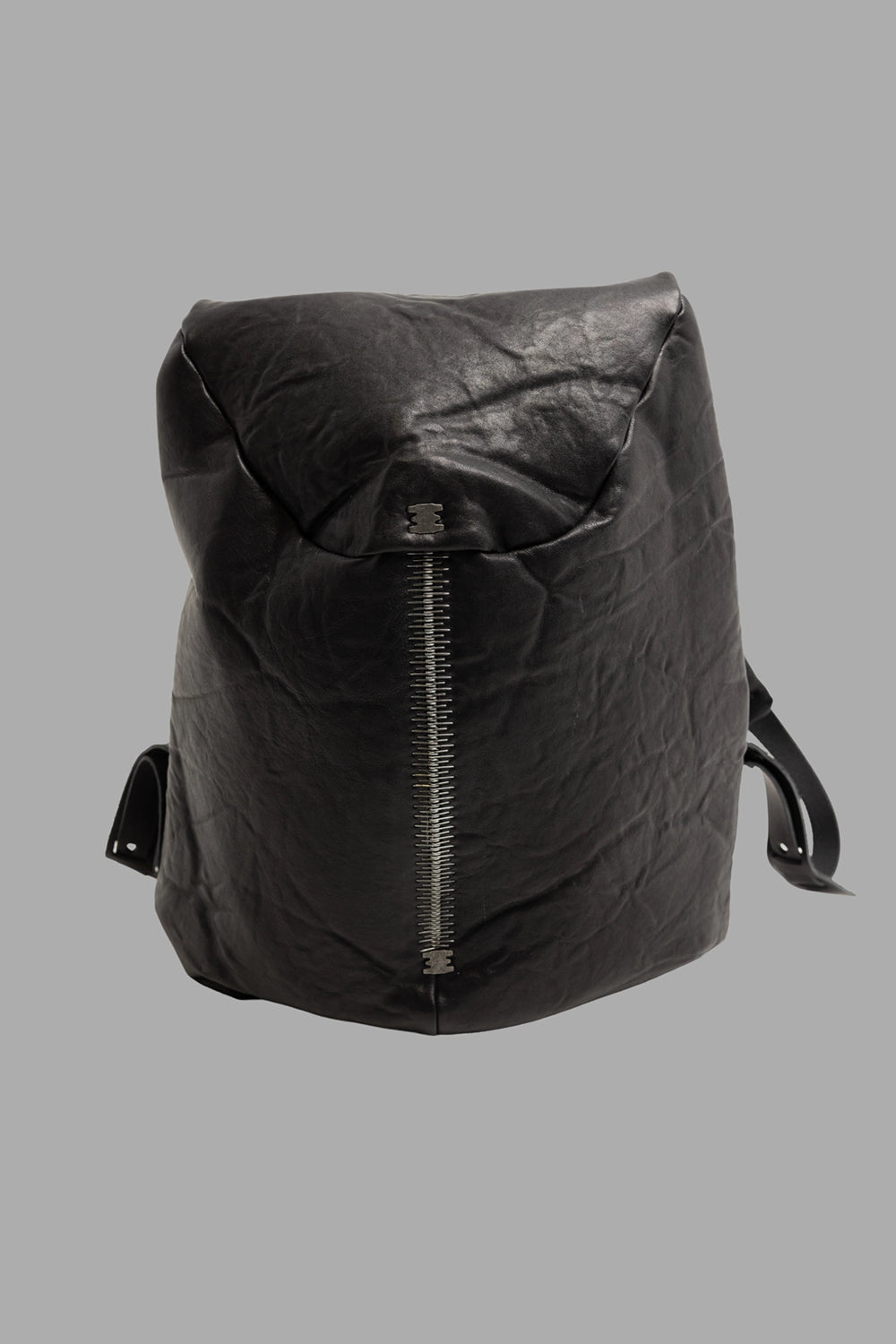 Isaac Sellam Experience unisex leather backpack in black, front view, vertical metal spine zip.