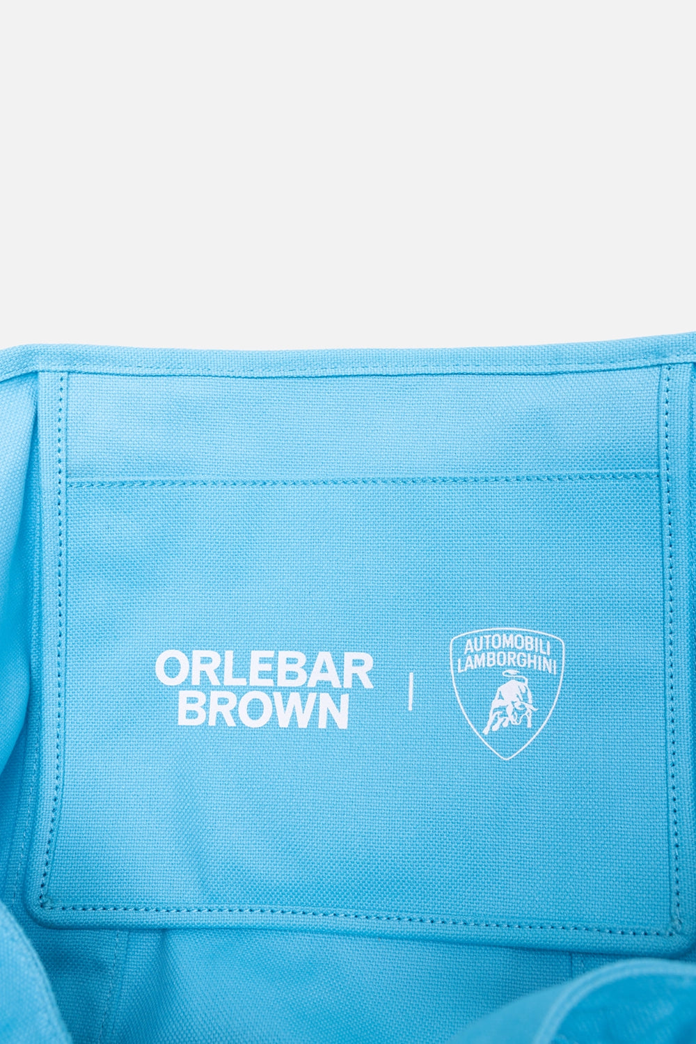 Orlebar Brown unisex beach tote bag in Synth Blue, back view, bold Orlebar Brown logo print with long handles
