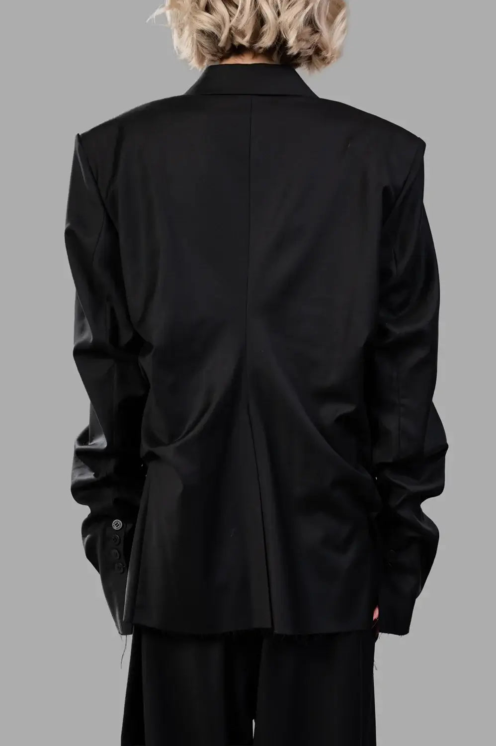 Natasha Zinko blazer in black wool‑blend, back view, raw‑edge hem and center back seam
