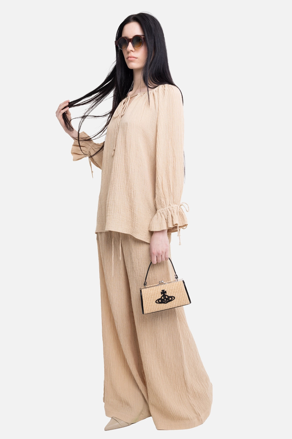 By Malene Birger women's blouse in dark sand, full-length on-model side view with tie neckline and ruffled cuffs