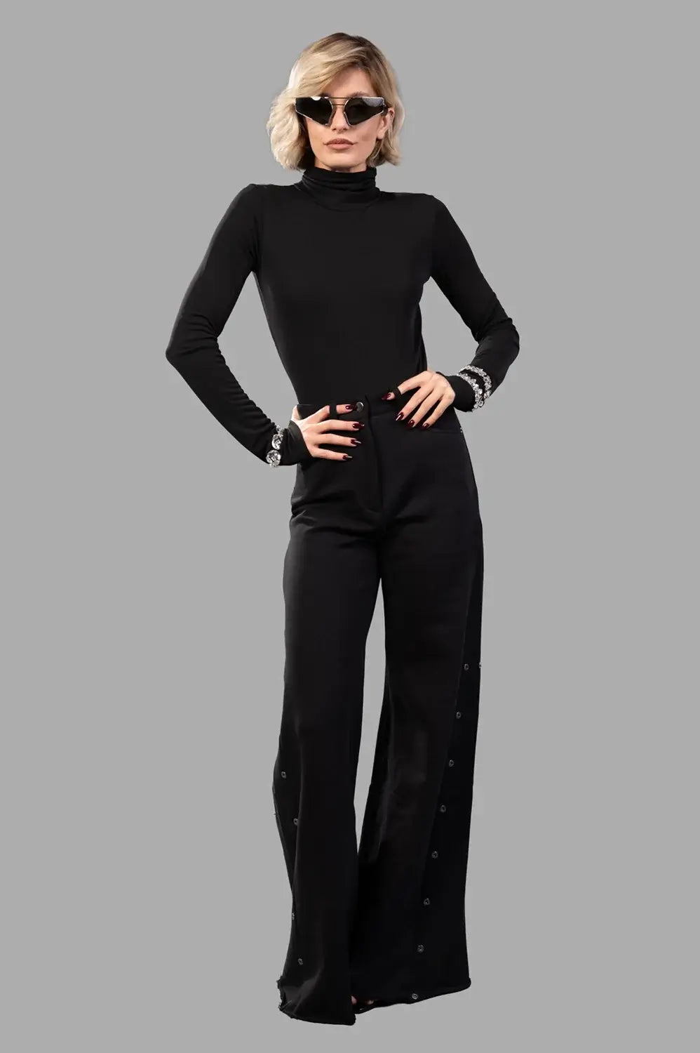 black high-neck bodysuit on model, full-length view, fluid jersey with crystal-embellished cuffs