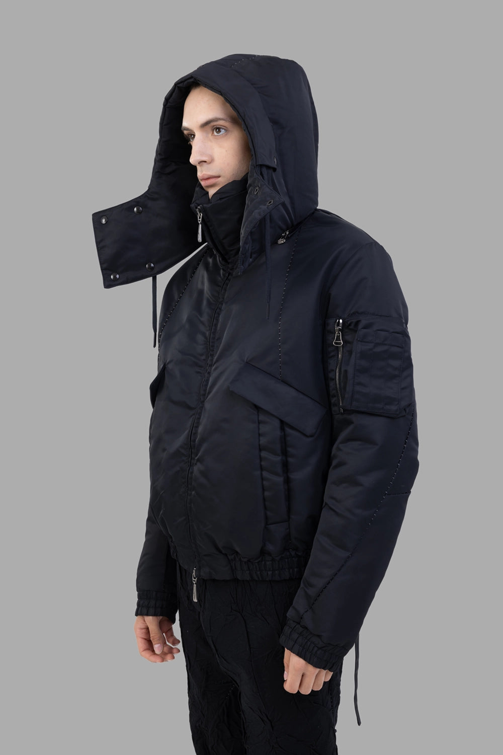 Masnada bomber jacket in black, 3/4 view, hood up with visor snaps