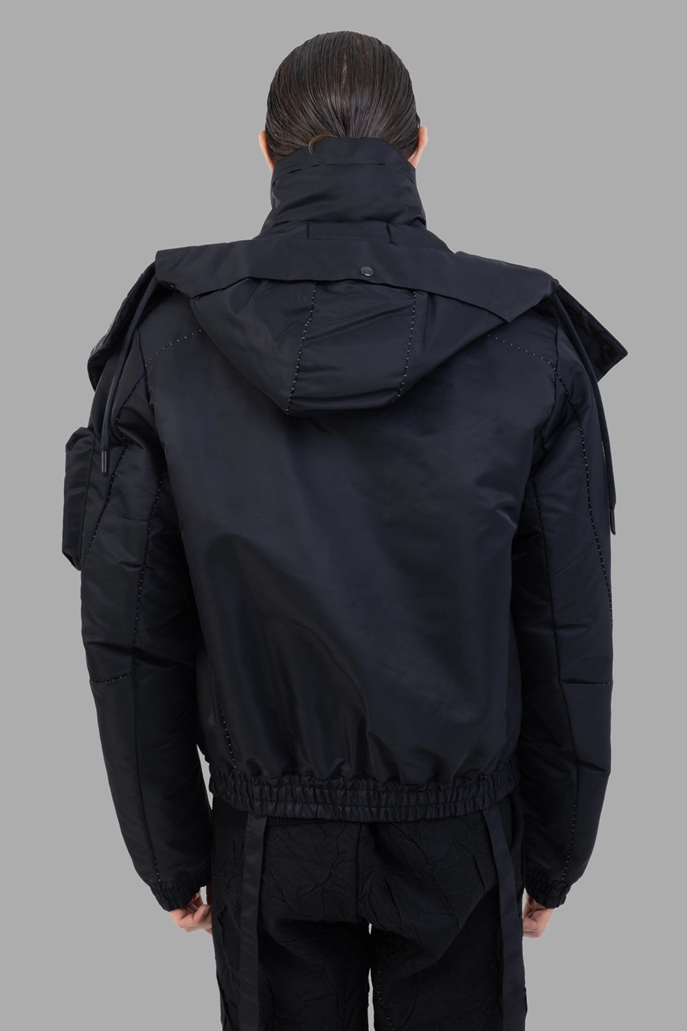 Masnada bomber jacket in black, back view, detachable hood panel and gathered hem