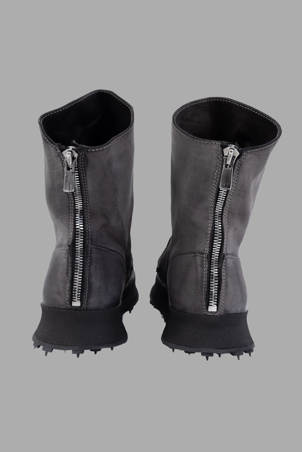 Shoto women ankle boots in Cenere, back view, exposed metal zippers and raised tread.