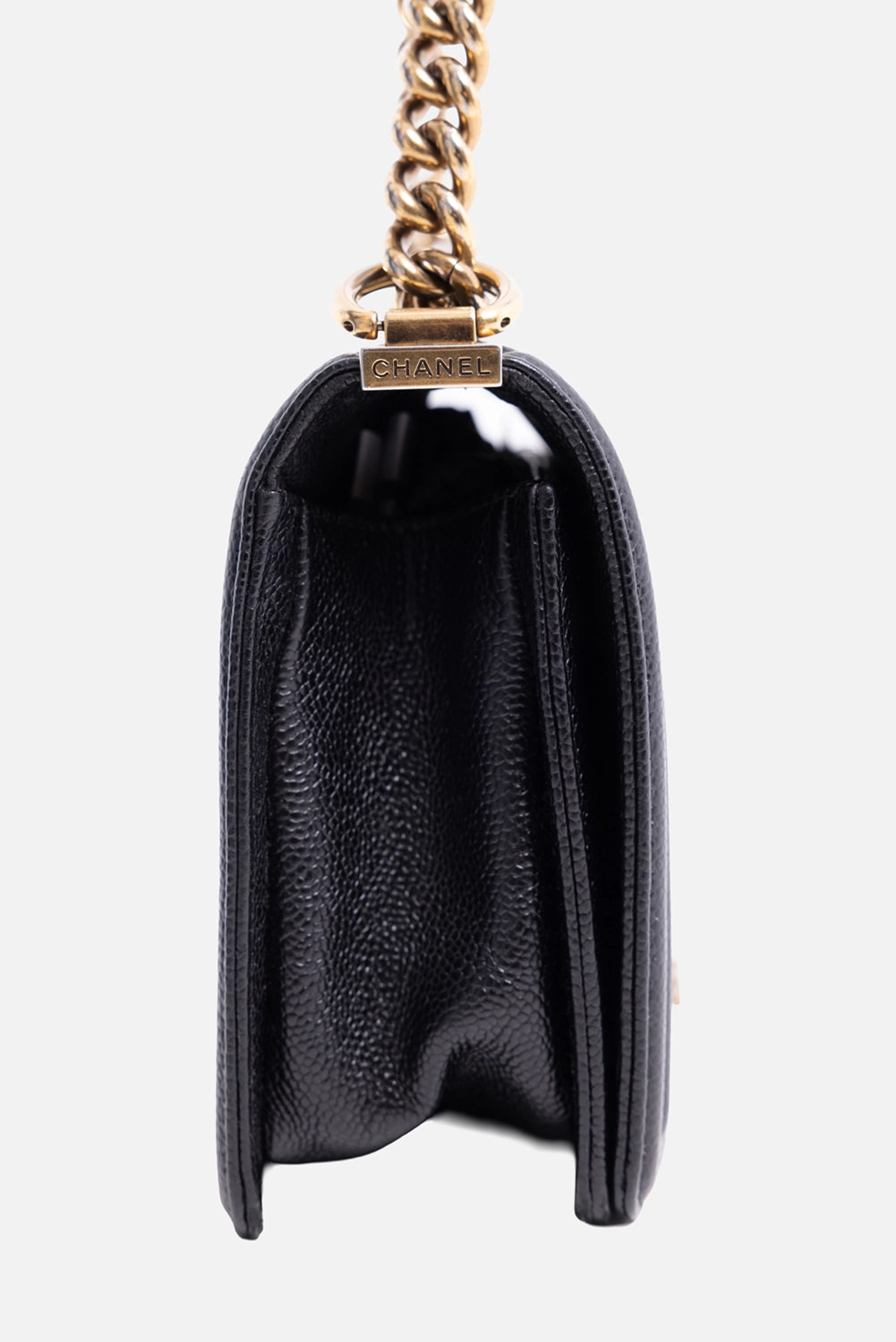 Pre-owned Chanel women's Boy Bag in black, side view, structured gusset with logo plaque at chain ring