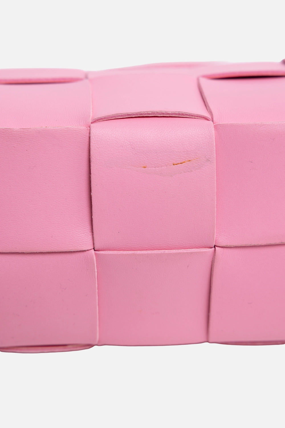 Pre-owned Bottega Veneta women's brick cassette bag in pink, bottom-detail view, close-up of light scratch on woven leather