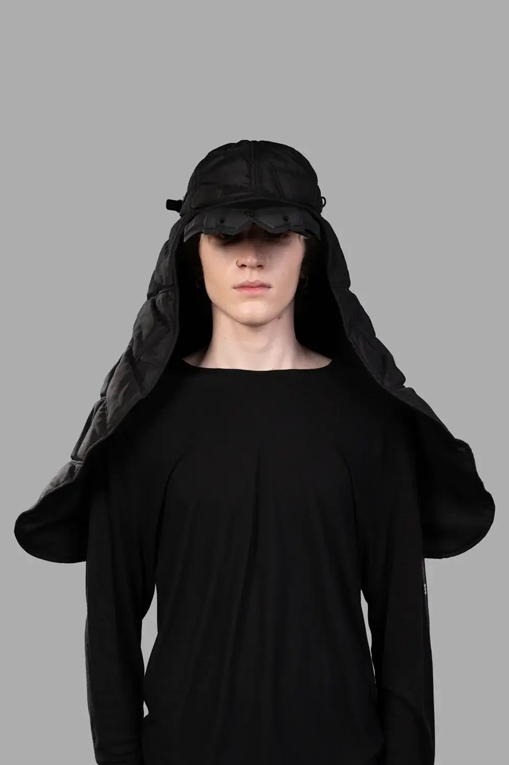 Model wearing black puffer scarf cap with quilted veil, full-length front view