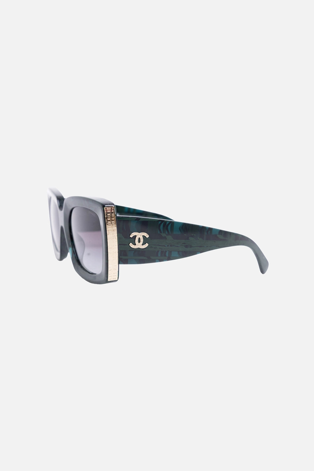 Side view of Chanel sunglasses showing gold-tone interlocking CC logo and metal temple detail
