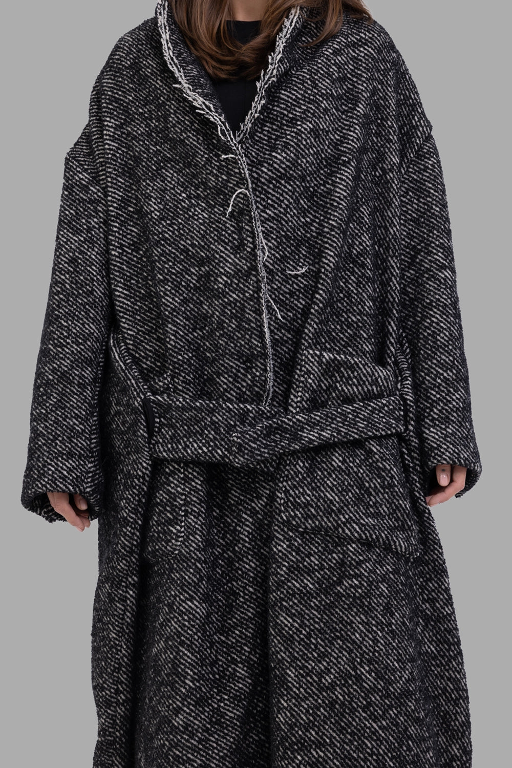 Giovanni Cavagna women coat in black, three-quarter view, textured weave and soft dropped shoulders.