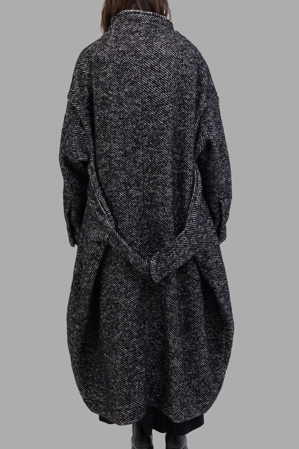 Giovanni Cavagna women coat in black, back view, draped belt detail and rounded hem.
