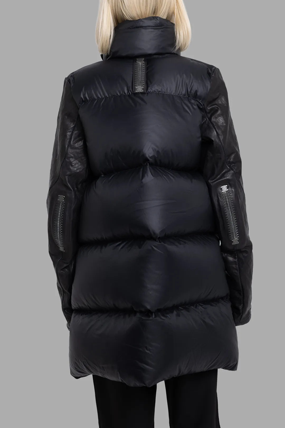 Isaac Sellam Experience unisex black coat, back view, quilted down-style panels and signature stapled spine tab.