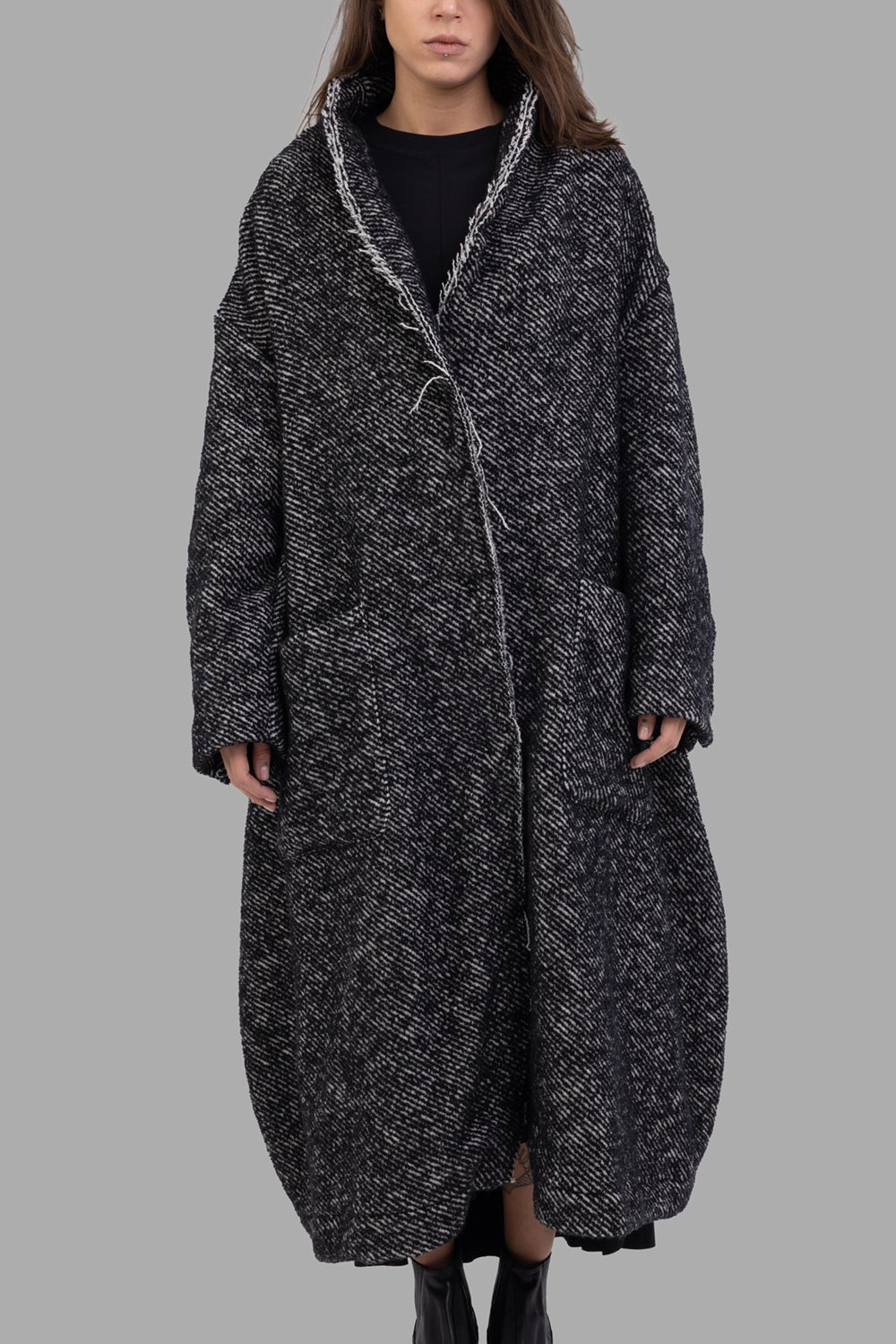 Giovanni Cavagna women coat in black, front view, raw-edge lapels and deep patch pockets.