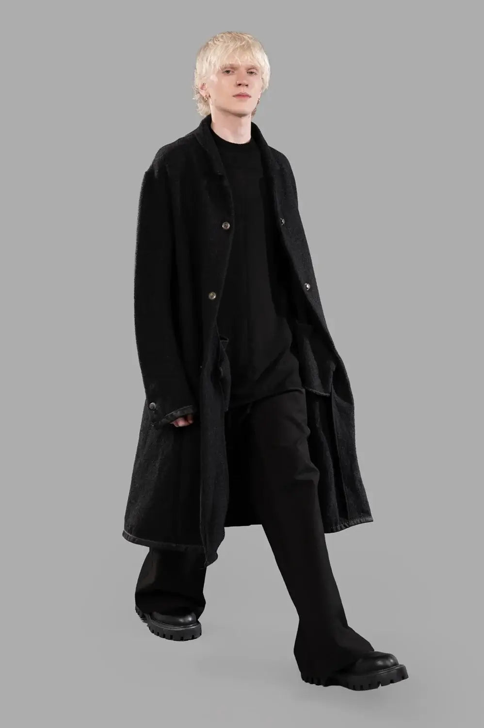 69 by Isaac Sellam coat in black, on-model full length, longline silhouette and leather-bound hem