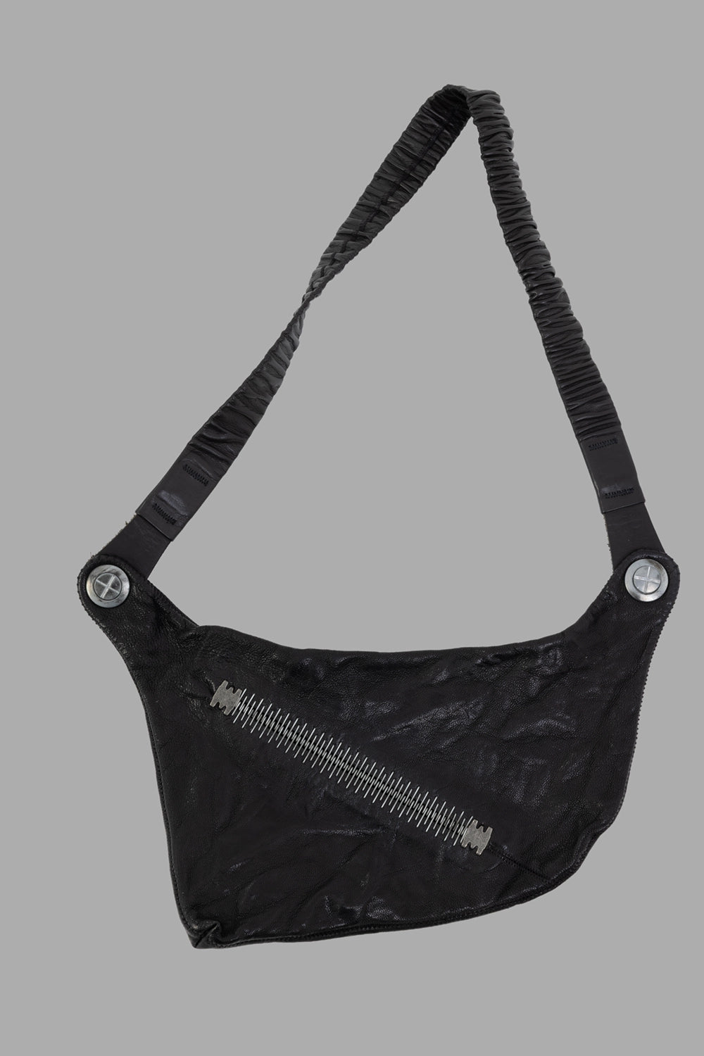 Isaac Sellam crossbody bag in black, front view, diagonal staple zip and pleated elastic strap