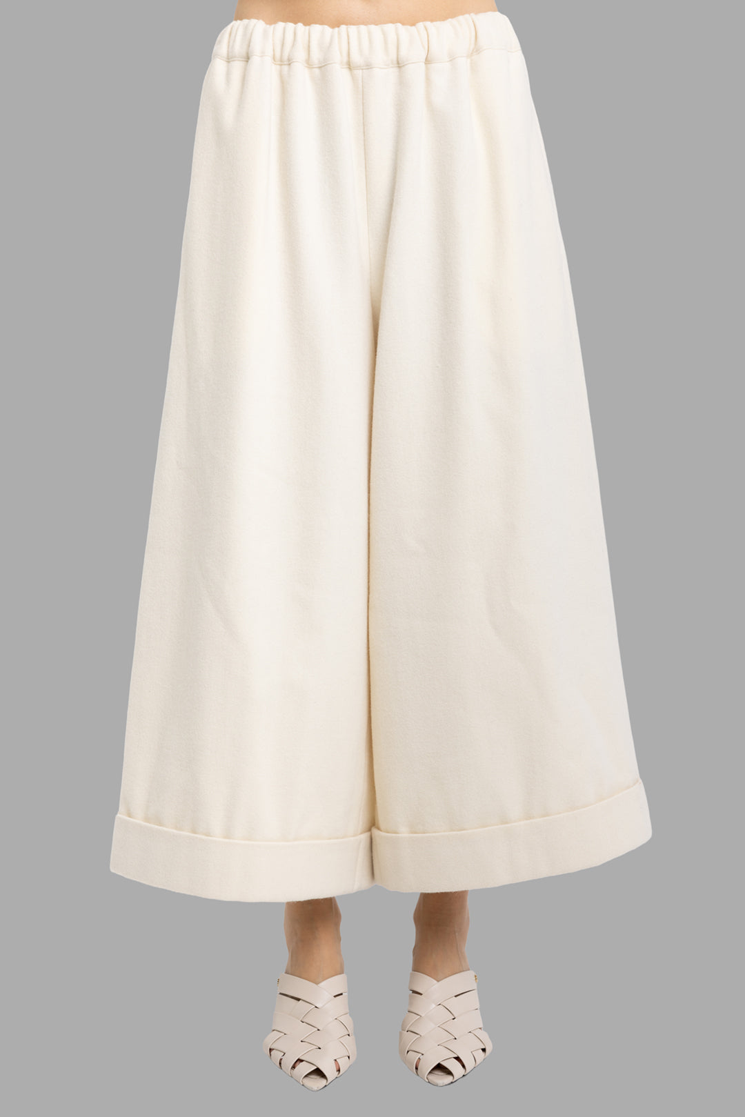 Comme des Garçons women's ivory wool culottes, front view, elastic waist and wide cropped legs with cuffed hem.