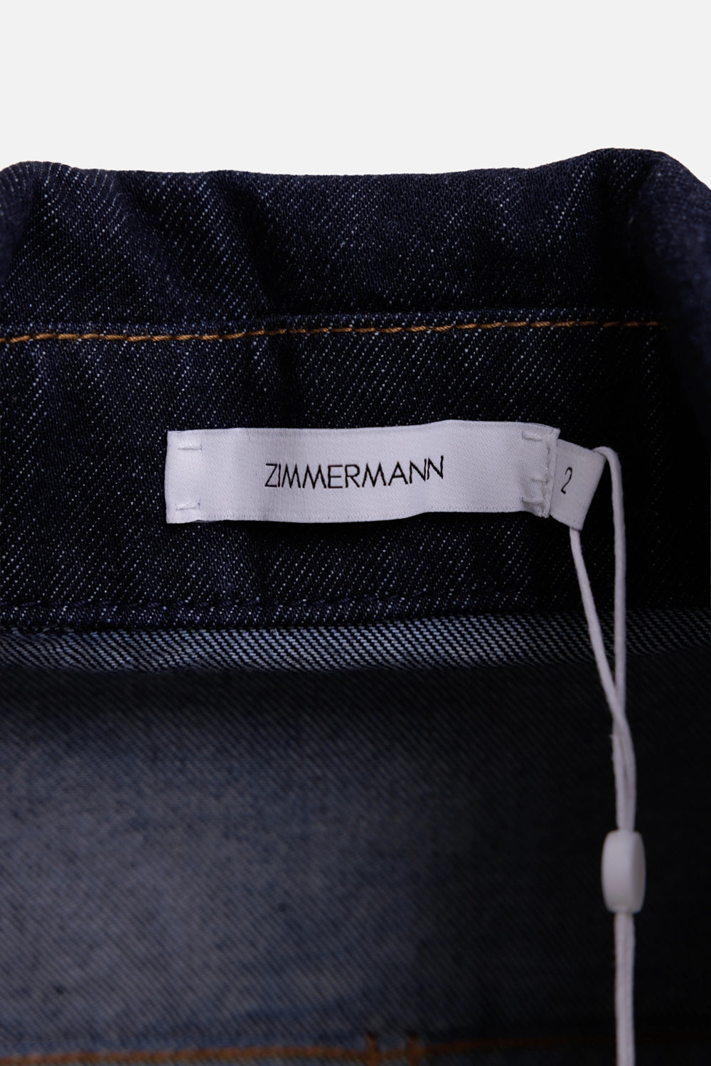 Zimmermann women's denim playsuit in Night Sky, label detail, white neck tag with size 2 beside collar