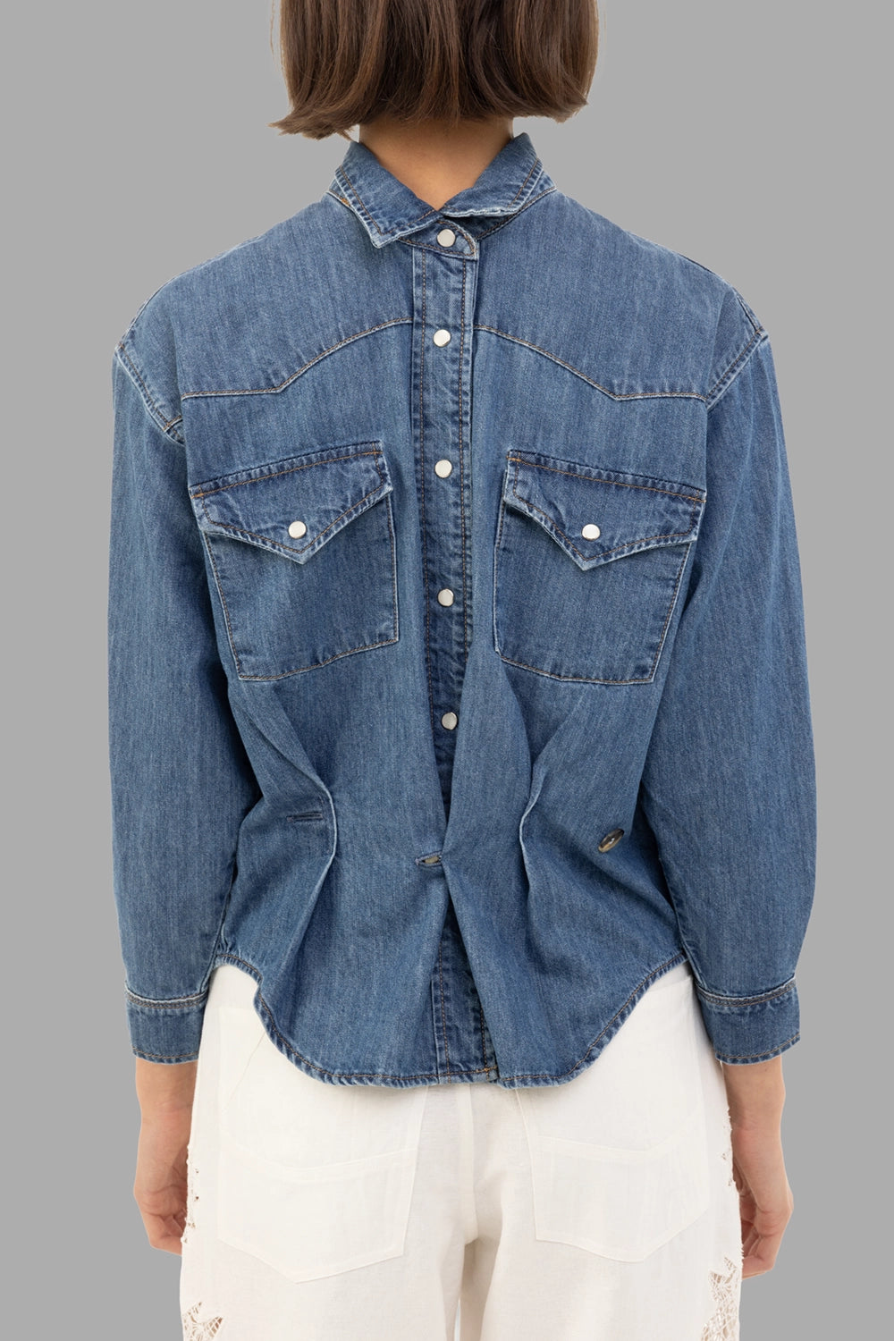 A.W.A.K.E. MODE women’s denim shirt in mid blue, back view, center snap placket and twin flap chest pockets