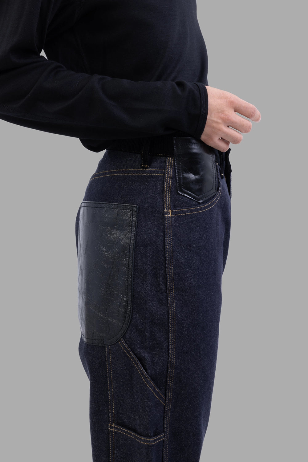 Junya Watanabe denim trousers in indigo, back view, leather-patch pockets