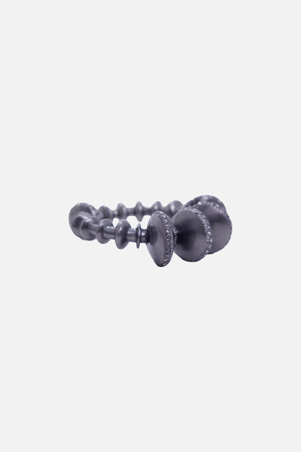 Kundo unisex disc bracelet in blackened silver-tone, three-quarter view with raised forms and stacked spacers
