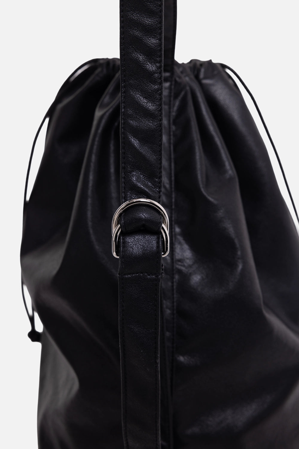 ATTACHMENT bucket bag in black, hardware close-up, silver ring adjuster on the shoulder strap