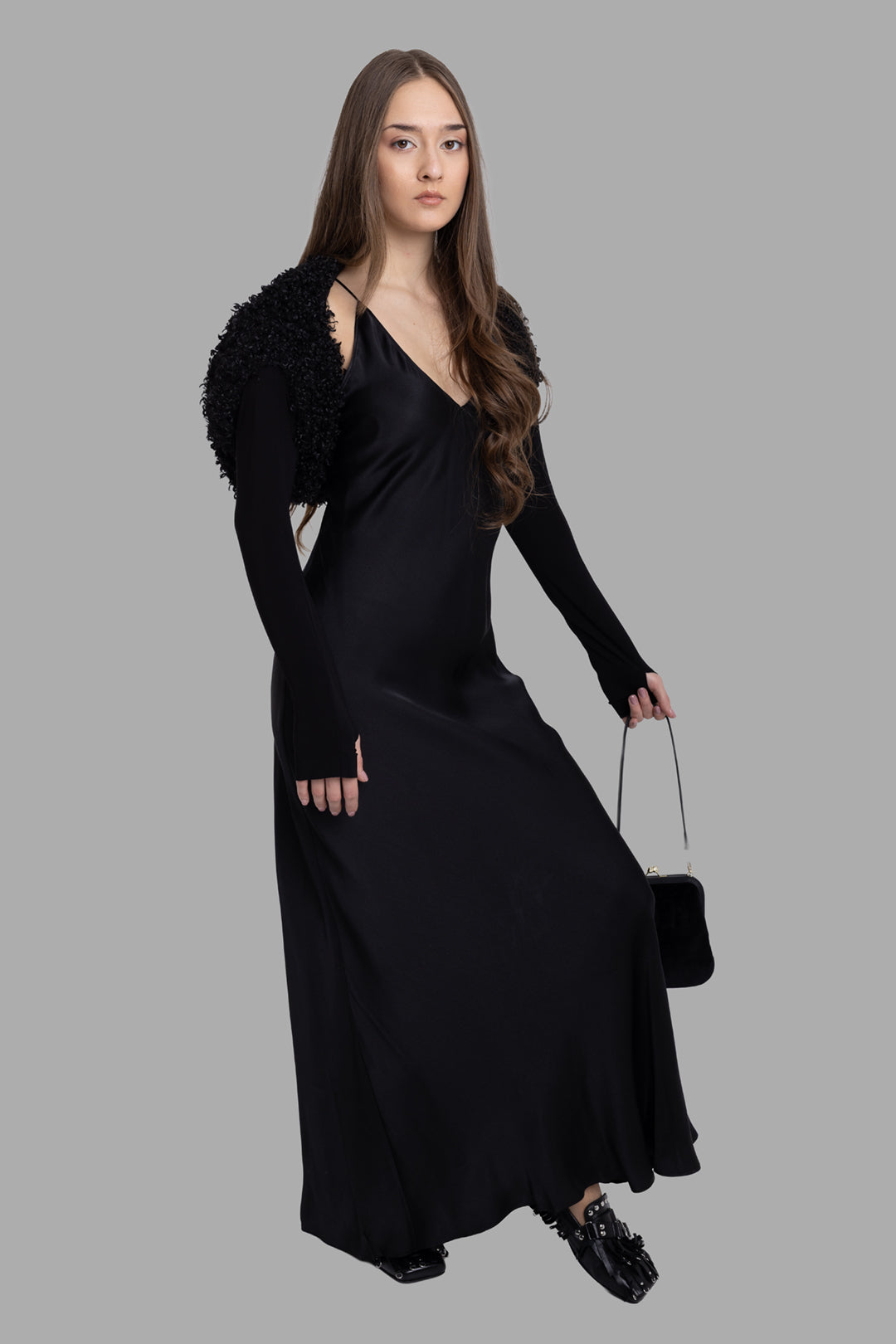 Norma Kamali women's black faux fur long sleeve shrug, full-length front view on model, thumbhole jersey sleeves.