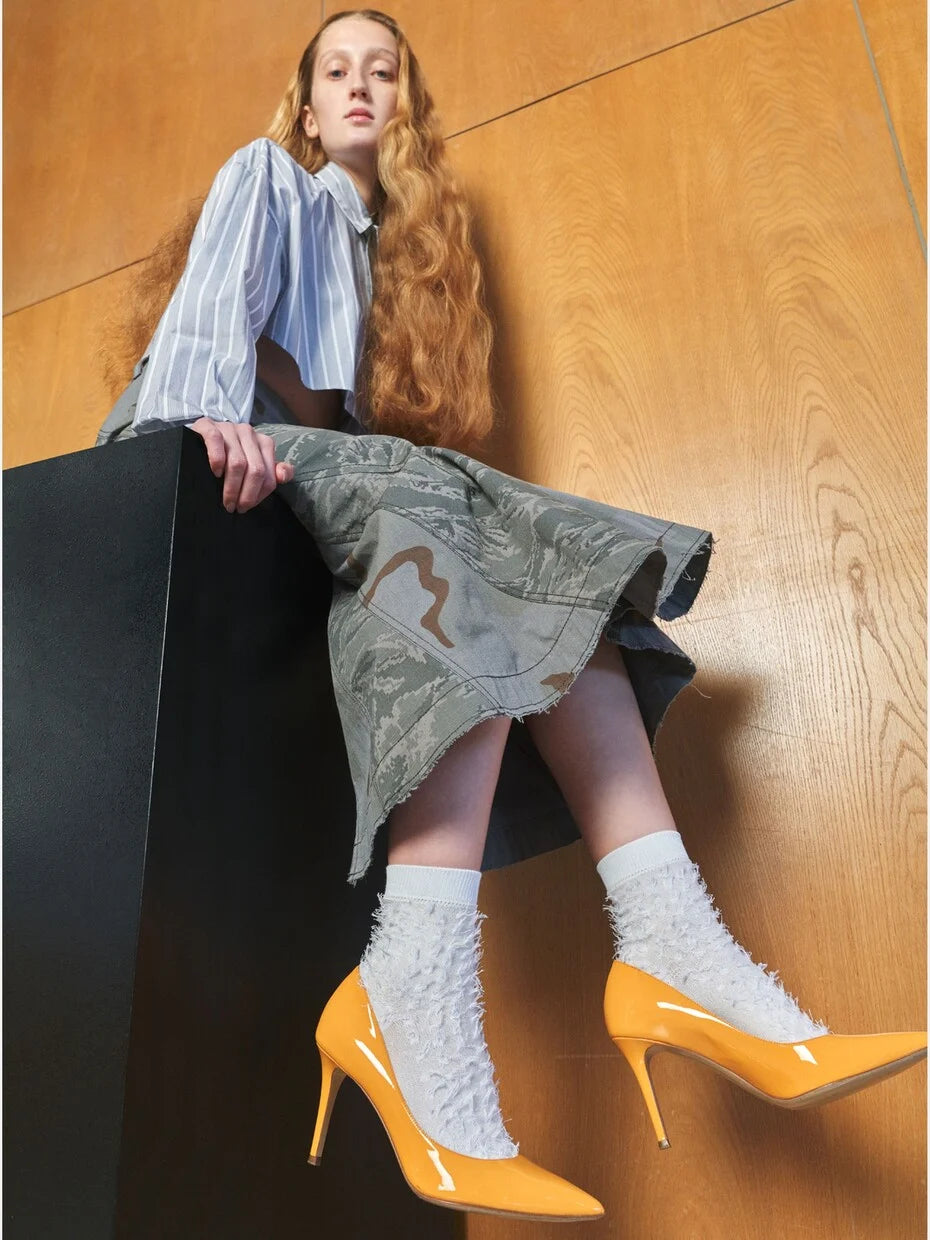 Tabio Fringe Style Low Crew Socks in white, showcasing a textured, tousled design, styled with yellow heels and a modern outfit.