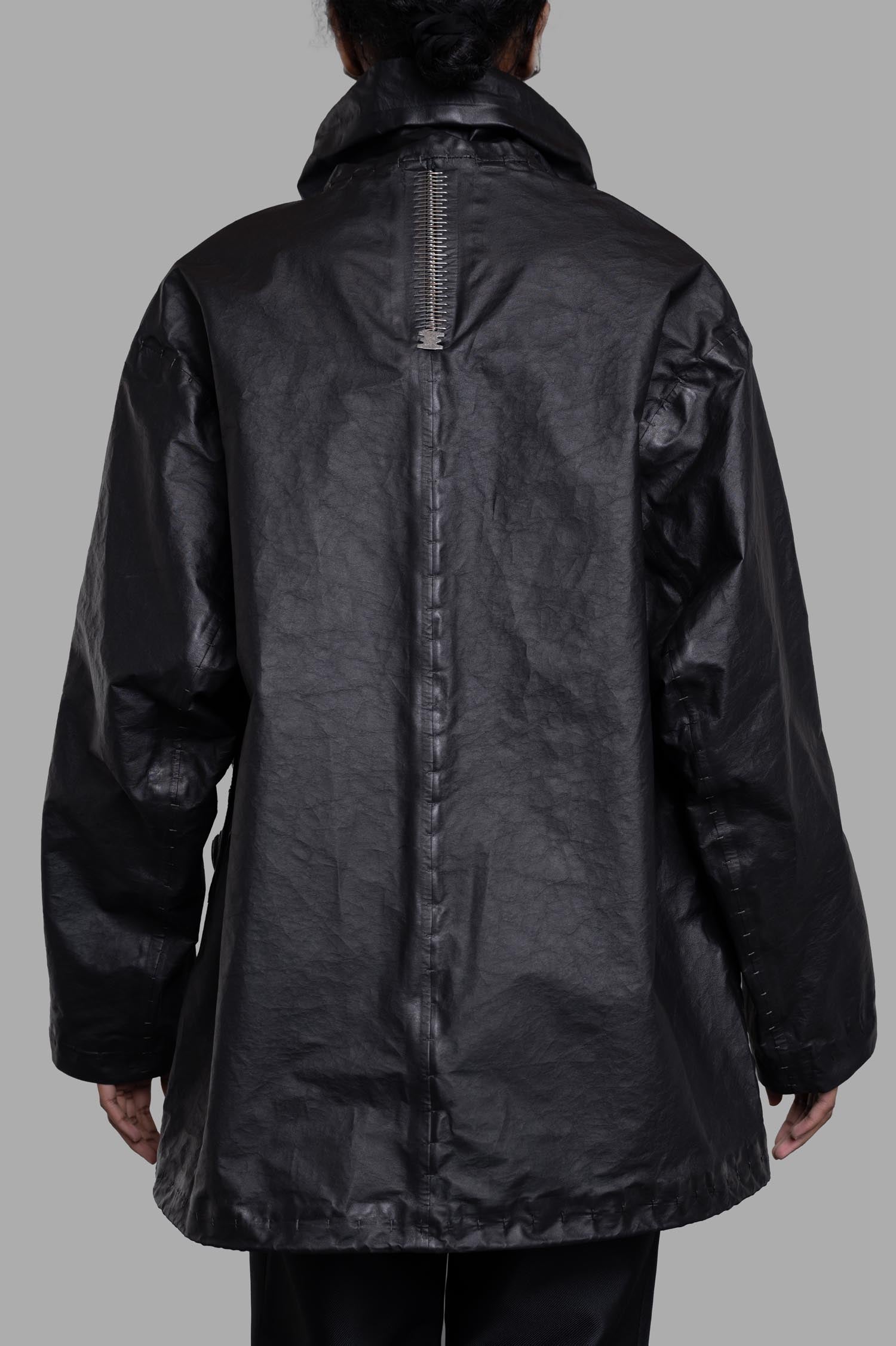 Isaac Sellam Oversized Jacket in black, featuring a unique spine zipper detail and relaxed silhouette, shown from the back.