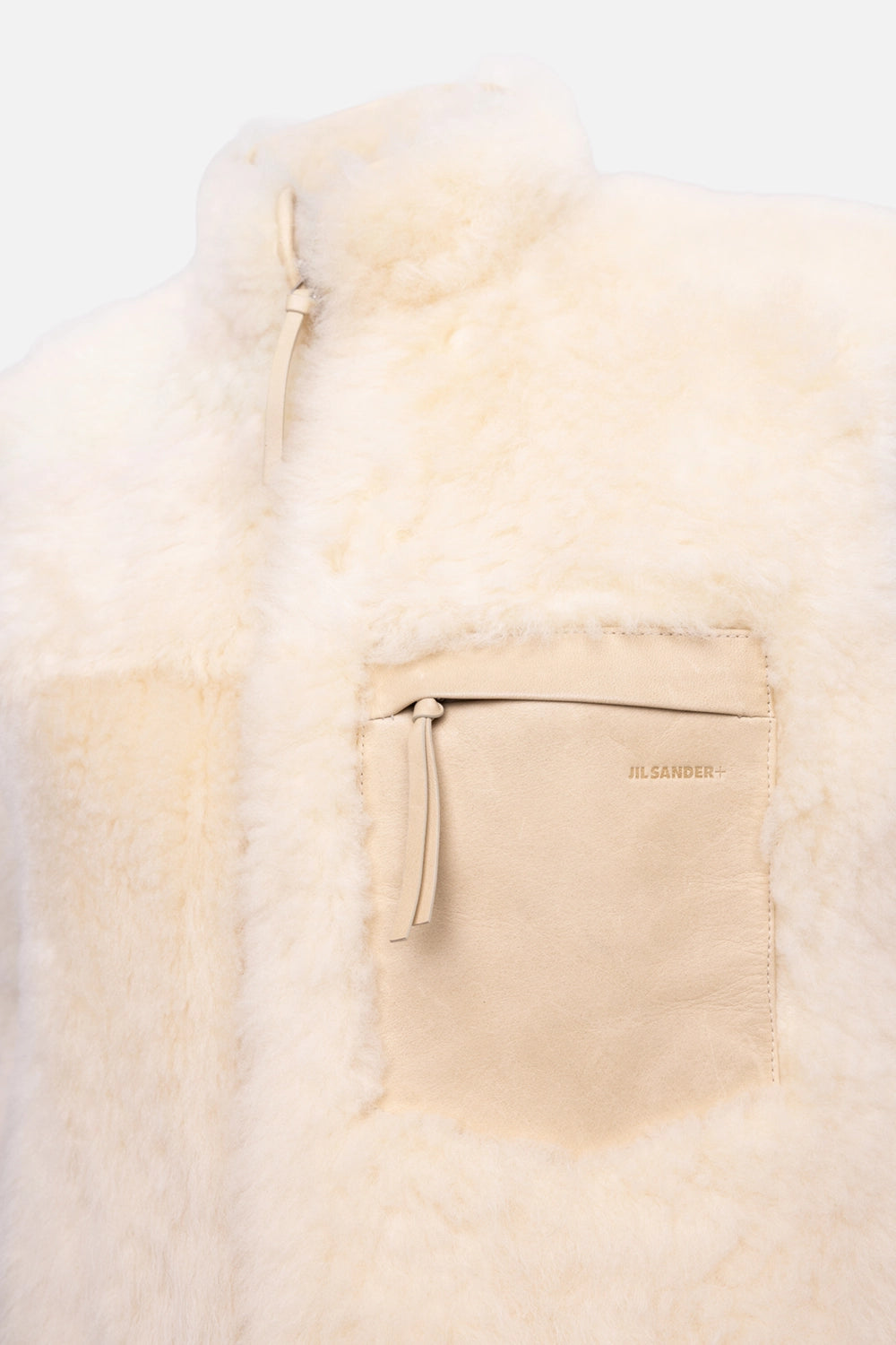Pre-owned Jil Sander women's shearling gilet in sand beige, logo-detail view, debossed logo on leather zip pocket
