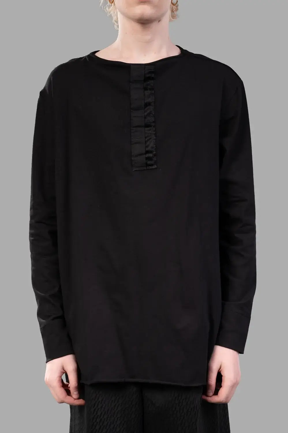 Front close-up showing crew neck and tonal satin placket; soft jersey texture
