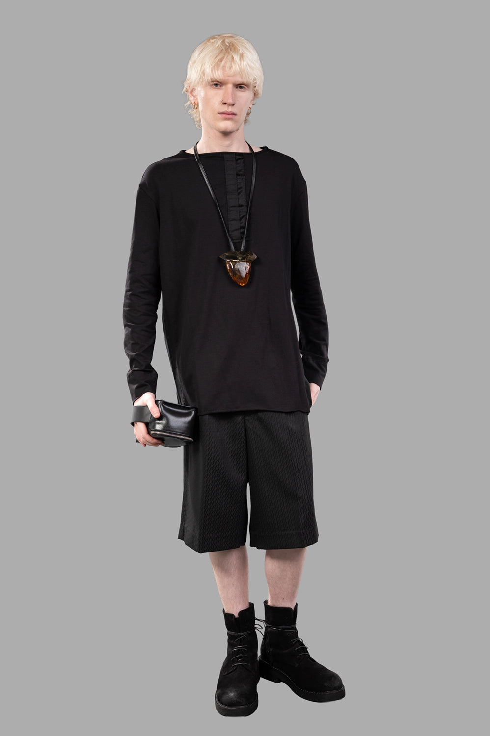 Full-length view of black long-sleeve tee with satin placket detail; relaxed fit