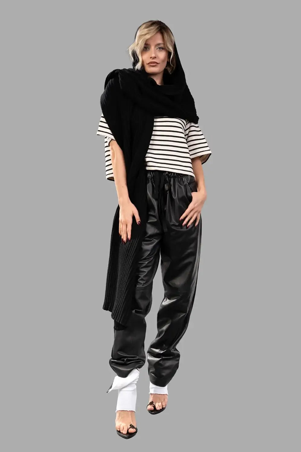 Full-length view of black drawstring pants with glossy front, relaxed leg and gathered waist