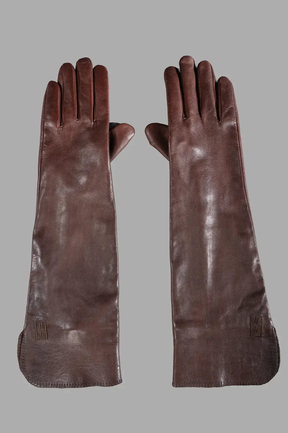 Pair of long brown leather gloves with extended cuffs and smooth finish, front view