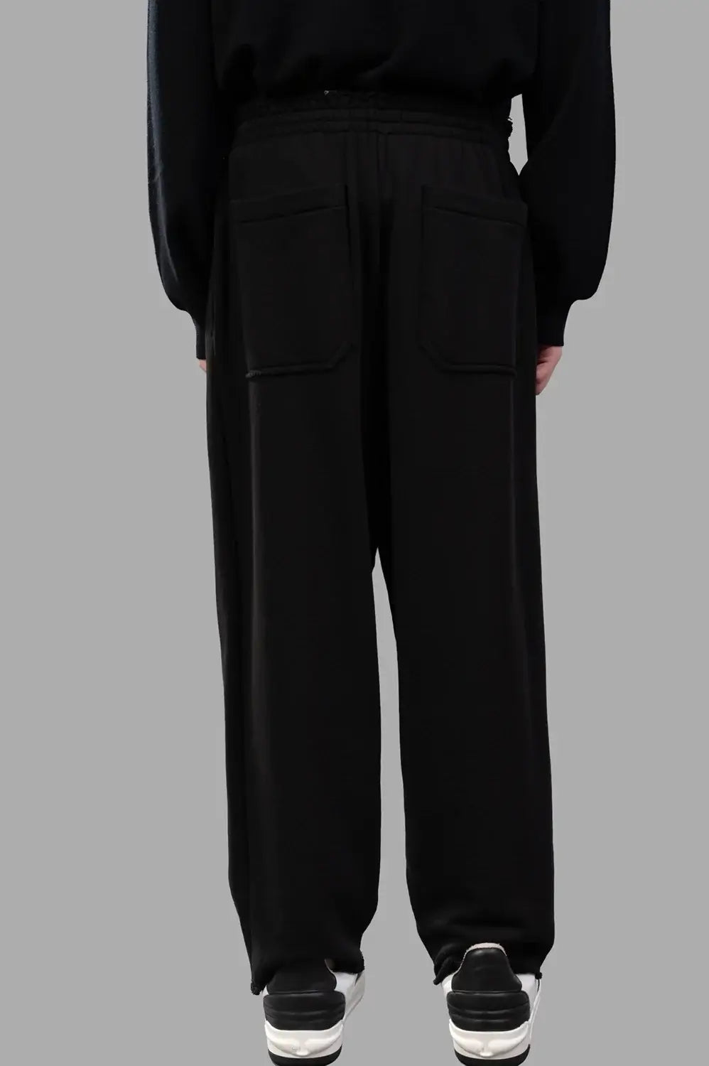 Front close-up of sweatpants waistband with rubber patch and drawstring