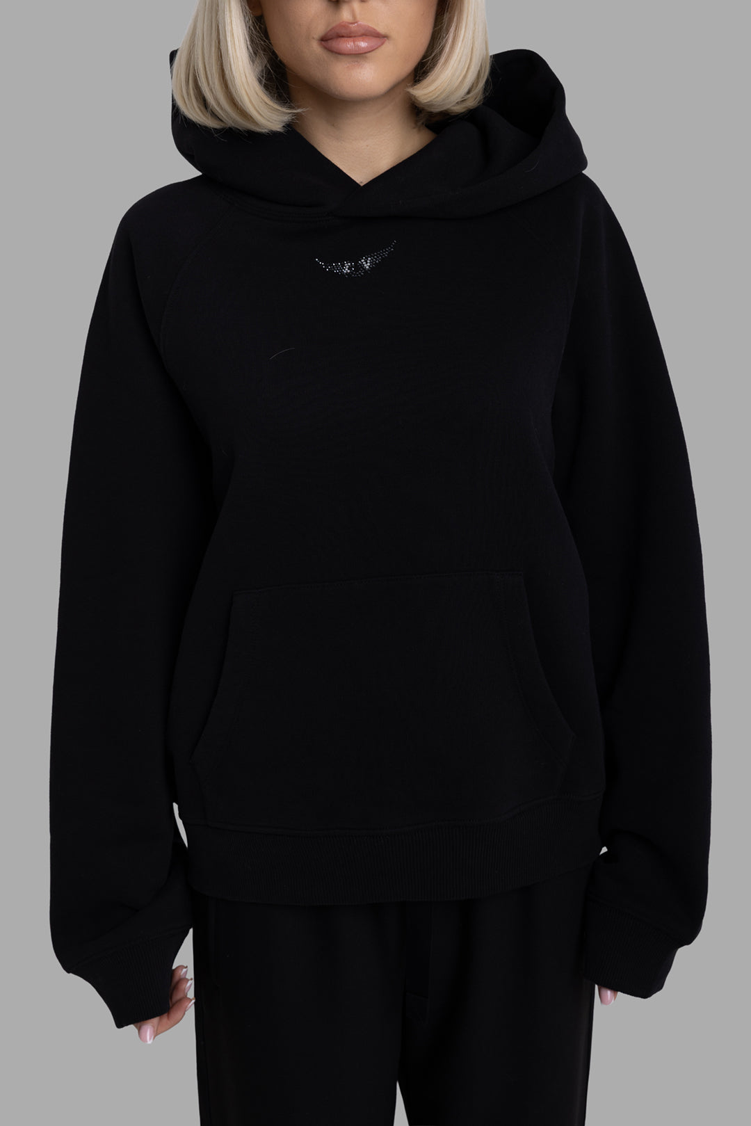Zadig & Voltaire women's black hoodie, front view, kangaroo pocket and rhinestone wings motif under hood.