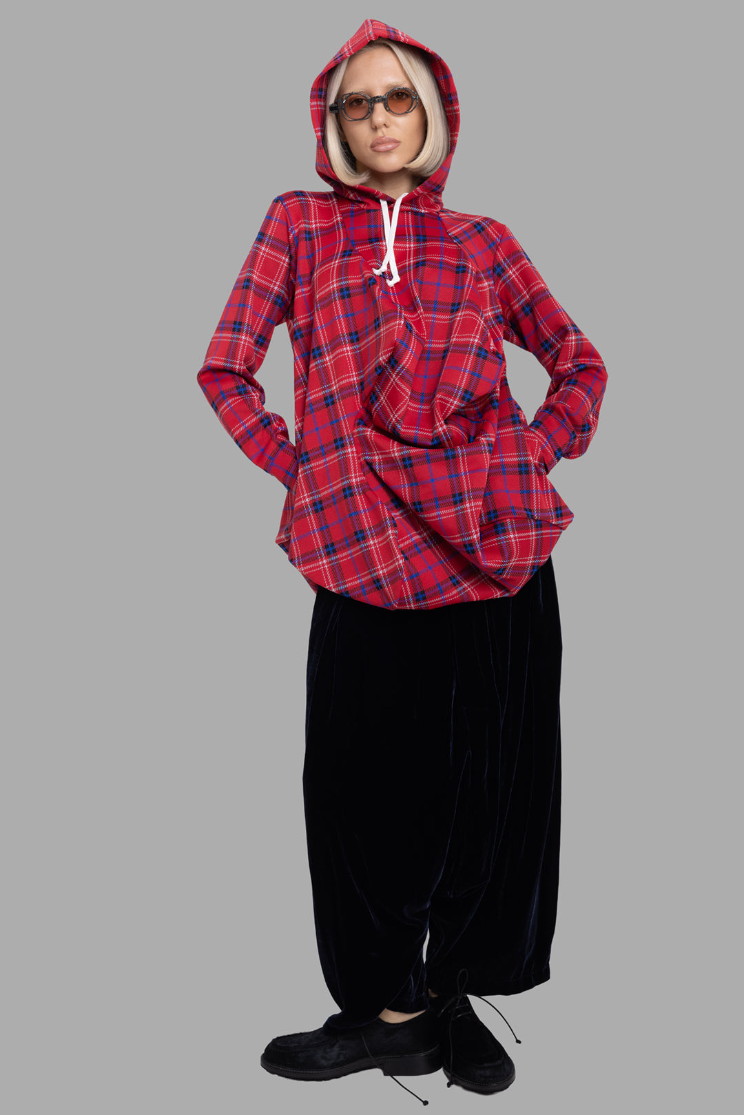 Comme des Garçons women's red tartan hoodie, on-model full-length, curved front drape and white drawstring hood.